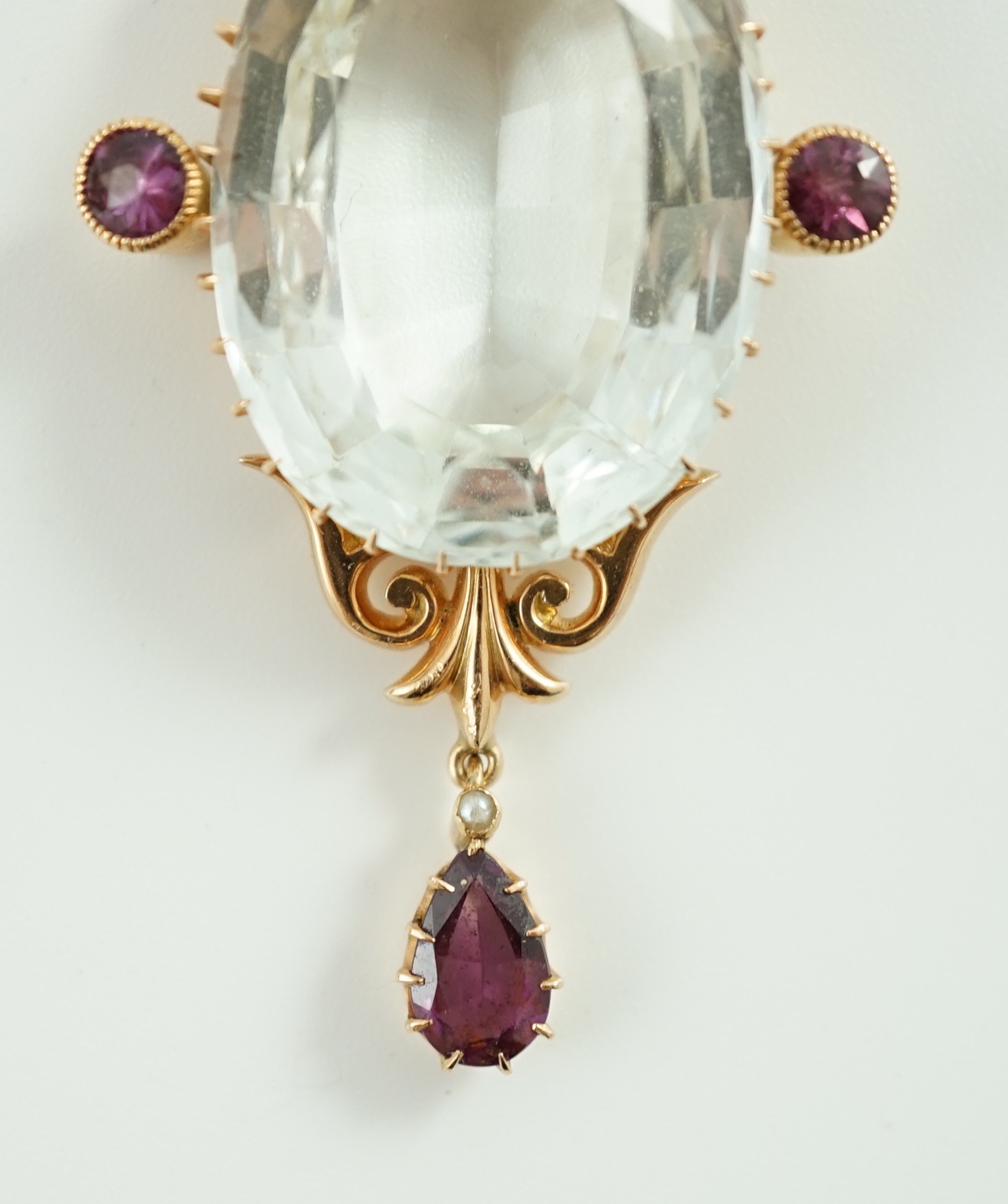 An early 20th century gold, aquamarine and garnet cluster set drop pendant, on a gold fine link chain